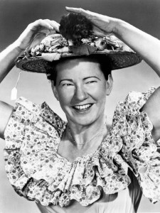 Black and White Photo of a smiling Woman in a colorful dress and a easter hat with the price tag still on